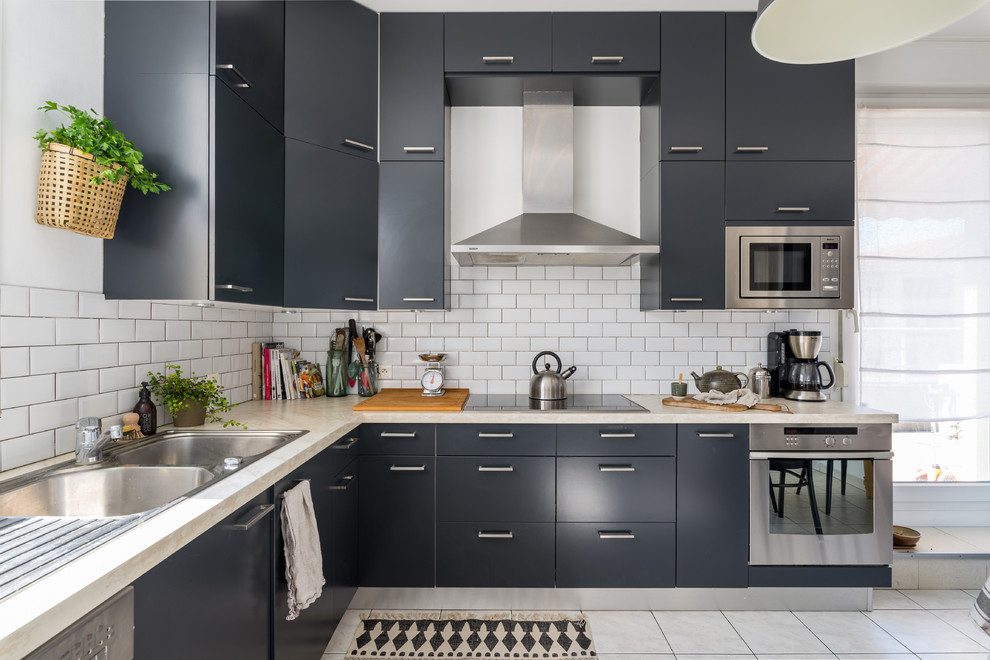 This is an example of a large scandinavian l-shaped eat-in kitchen in Lyon with a double-bowl sink, black cabinets, white splashback, stainless steel appliances, ceramic floors and no island.