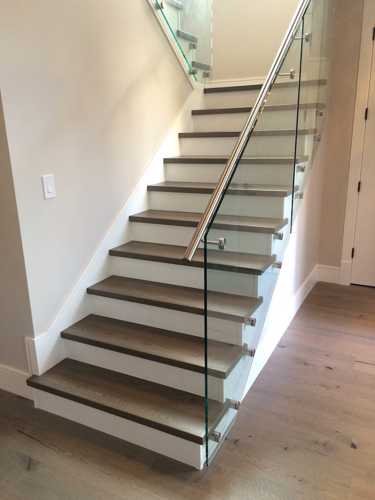 Photo of a mid-sized modern wood l-shaped staircase in Vancouver with painted wood risers and metal railing.