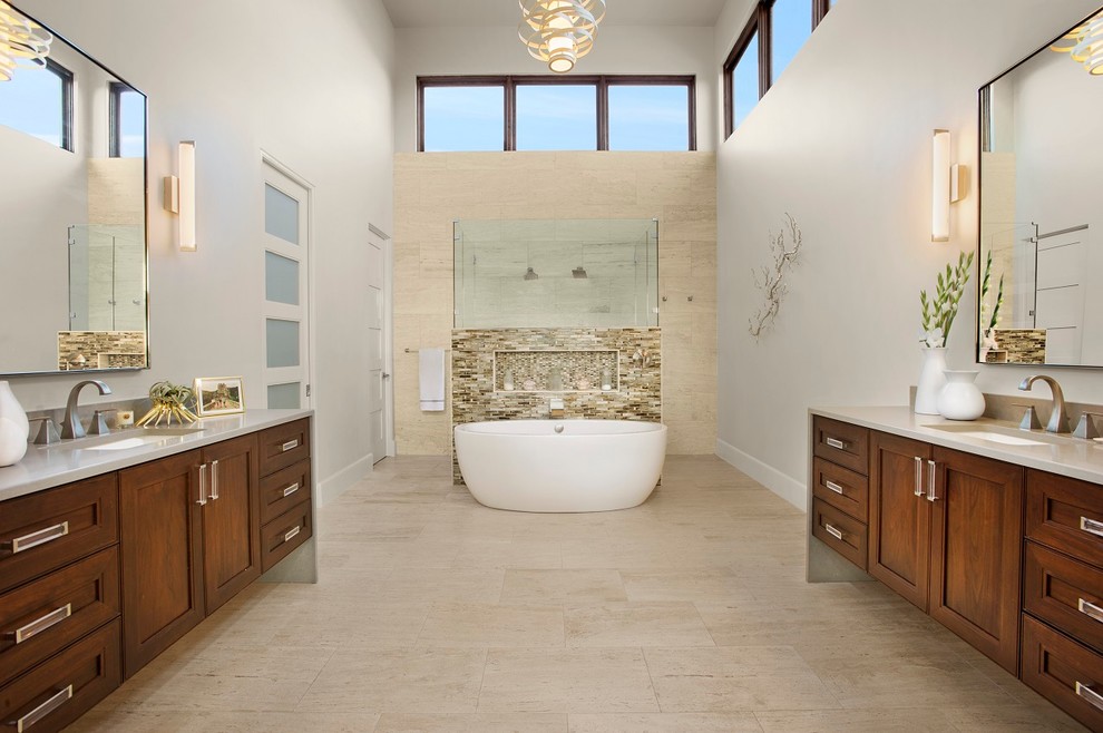 Design ideas for a large contemporary master bathroom in Austin with flat-panel cabinets, medium wood cabinets, a freestanding tub, an open shower, a one-piece toilet, beige tile, stone tile, white walls, travertine floors, an undermount sink and onyx benchtops.