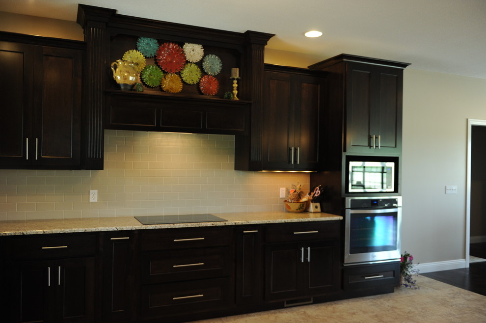 Inspiration for a huge transitional u-shaped porcelain tile eat-in kitchen remodel in Chicago with an undermount sink, shaker cabinets, dark wood cabinets, granite countertops, beige backsplash, ceramic backsplash, stainless steel appliances and a peninsula