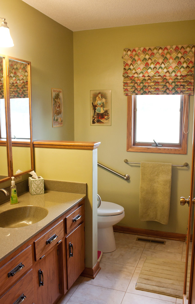 Mid-sized traditional bathroom in Wichita with green walls, vinyl floors and solid surface benchtops.