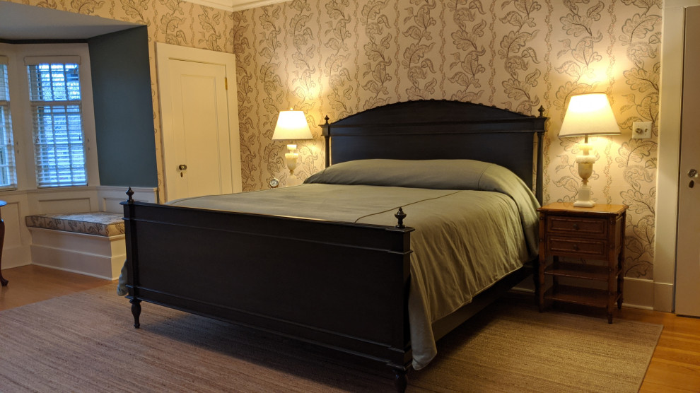 На фото: гостевая спальня среднего размера, (комната для гостей) в классическом стиле с бежевыми стенами, светлым паркетным полом, стандартным камином, фасадом камина из кирпича, коричневым полом и обоями на стенах с