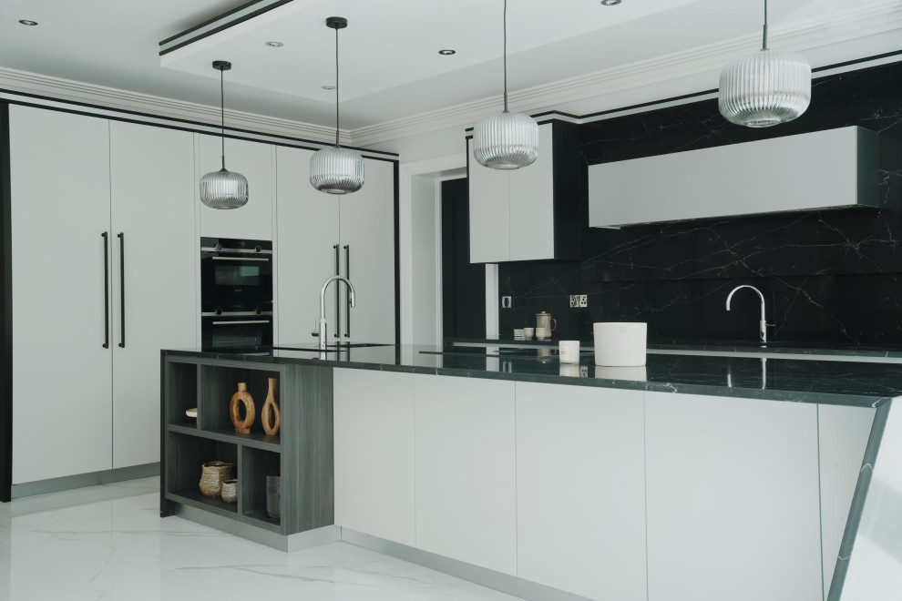 Inspiration for a large modern grey and black l-shaped kitchen/diner in Surrey with a built-in sink, flat-panel cabinets, grey cabinets, composite countertops, black splashback, engineered quartz splashback, black appliances, porcelain flooring, an island, white floors, black worktops, a coffered ceiling and feature lighting.