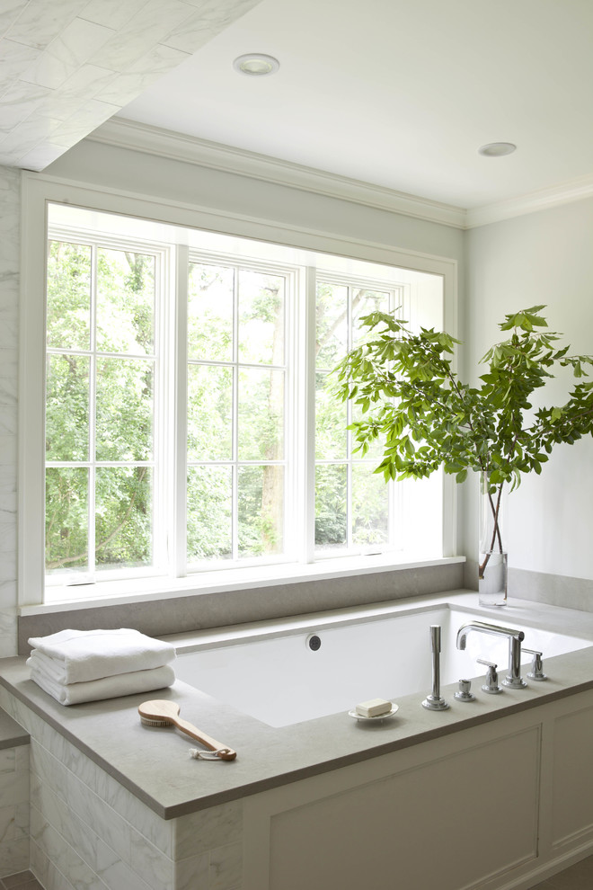 Photo of a transitional master bathroom in New York with an undermount tub and grey walls.