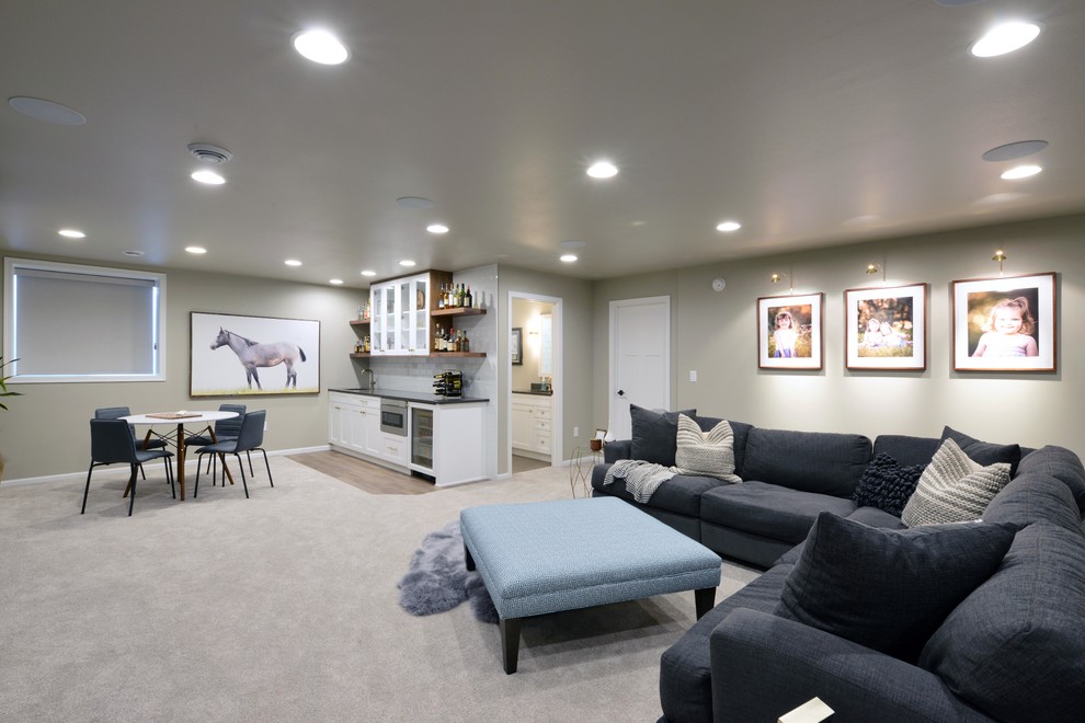Photo of a large modern look-out basement in Other with grey walls, carpet, a two-sided fireplace, a wood fireplace surround and beige floor.