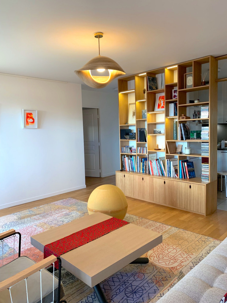 Foto di un soggiorno tradizionale di medie dimensioni con libreria, pareti bianche e pavimento in legno massello medio