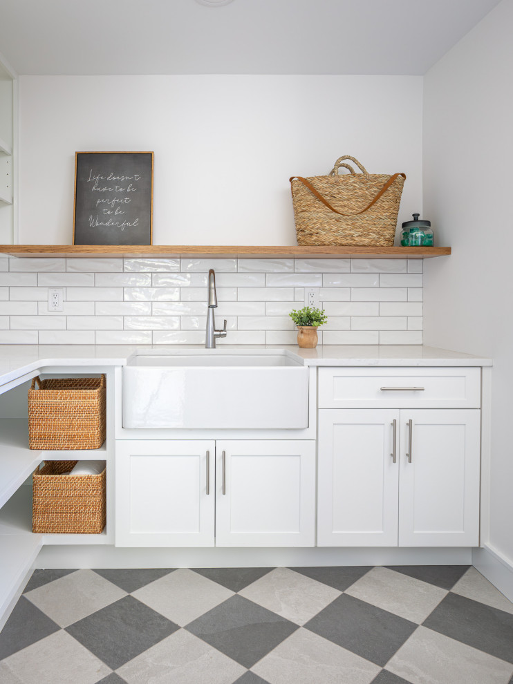 Photo of a mid-sized transitional u-shaped dedicated laundry room in Raleigh with a farmhouse sink, shaker cabinets, white cabinets, wood benchtops, white splashback, shiplap splashback, white walls, porcelain floors, a side-by-side washer and dryer, brown benchtop and planked wall panelling.