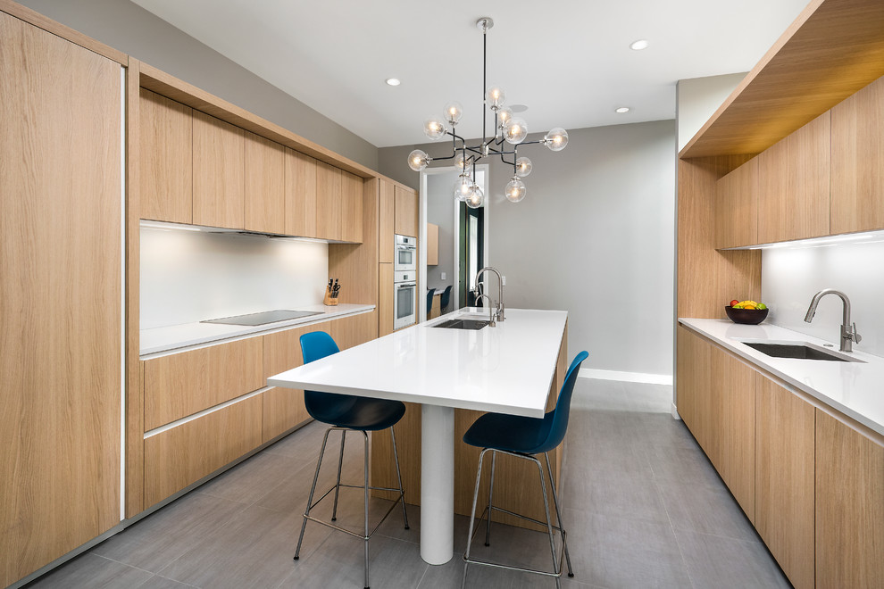 Contemporary separate kitchen in Chicago with an undermount sink, flat-panel cabinets, light wood cabinets, white splashback, white appliances, with island, quartz benchtops, glass sheet splashback and concrete floors.
