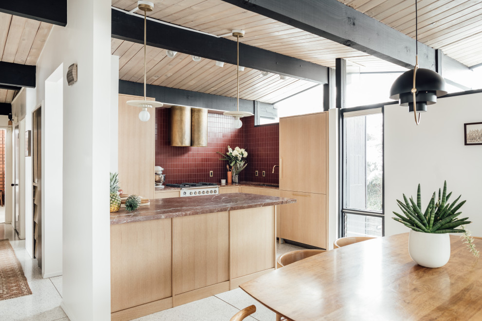 This is an example of a mid-sized midcentury l-shaped eat-in kitchen in Salt Lake City with an integrated sink, flat-panel cabinets, light wood cabinets, marble benchtops, red splashback, glass tile splashback, white appliances, terrazzo floors, a peninsula, grey floor, red benchtop and exposed beam.