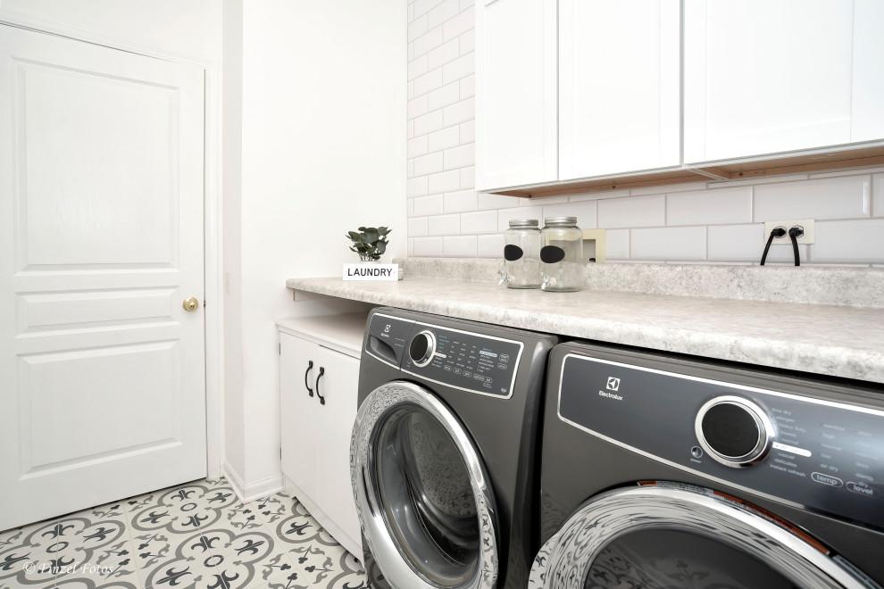 Mid-sized transitional dedicated laundry room in Chicago with shaker cabinets, white cabinets, laminate benchtops, white splashback, ceramic splashback, white walls, ceramic floors, a side-by-side washer and dryer, multi-coloured floor and grey benchtop.