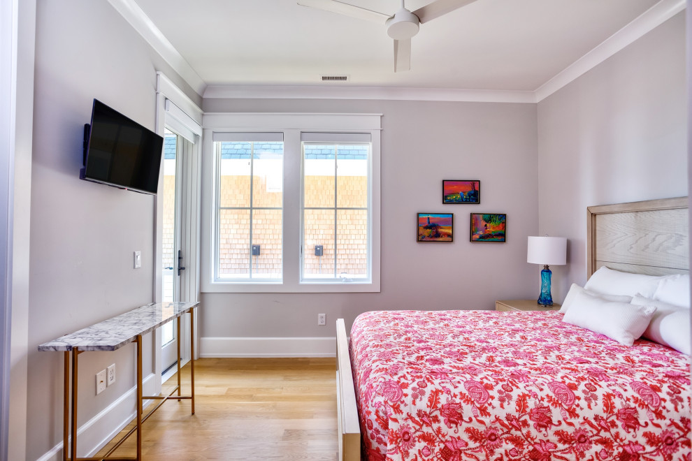 Foto di un'ampia camera degli ospiti stile marinaro con pareti bianche, pavimento in legno massello medio e pavimento marrone