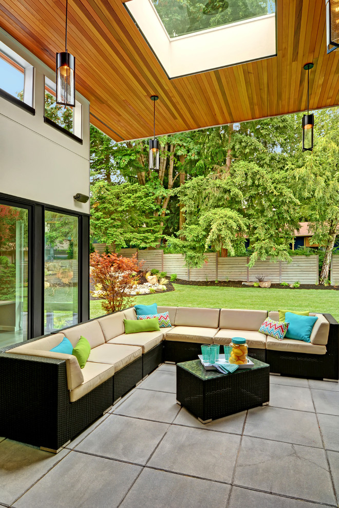 Photo of a contemporary patio in Seattle with a roof extension and concrete slab.