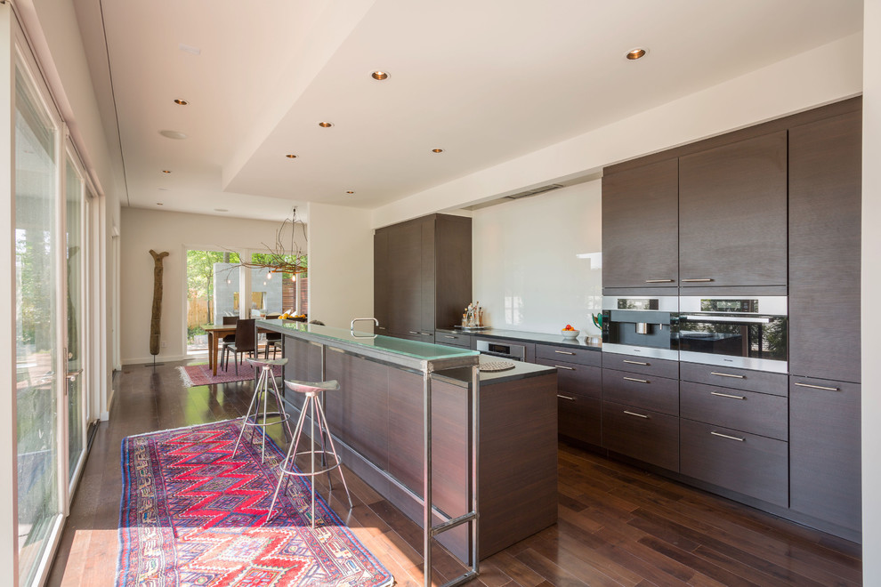 Inspiration for a mid-sized contemporary kitchen in Atlanta with an undermount sink, flat-panel cabinets, dark wood cabinets, quartz benchtops, white splashback, glass sheet splashback and stainless steel appliances.