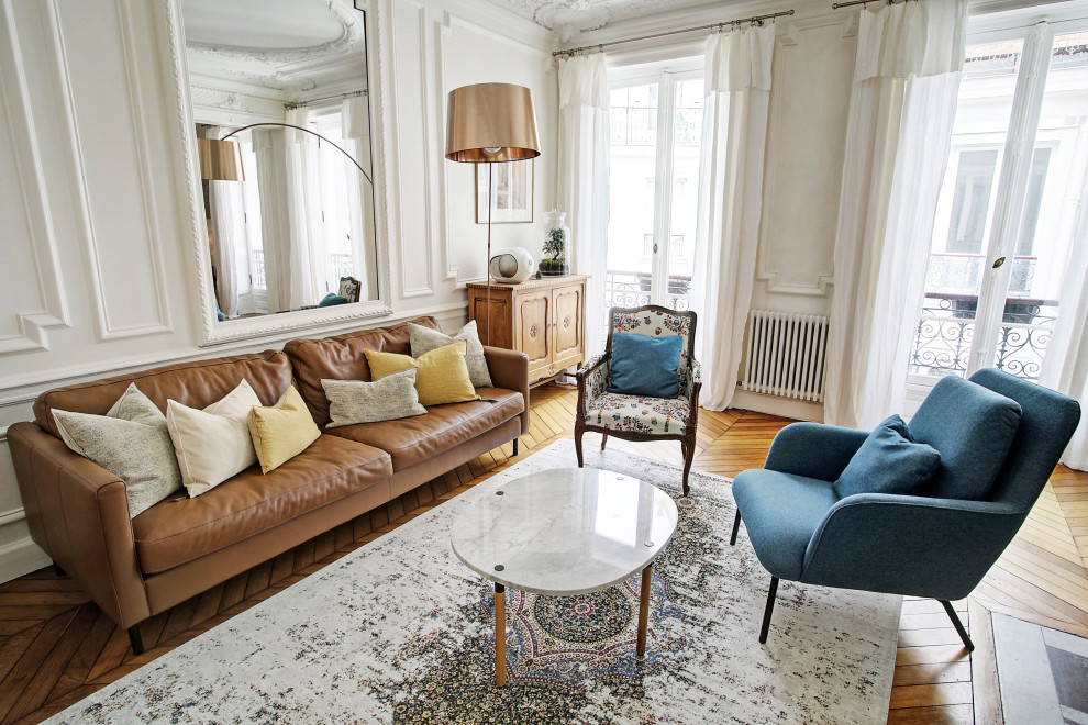 This is an example of a mid-sized contemporary formal open concept living room in Paris with white walls, medium hardwood floors, a standard fireplace, no tv and brown floor.