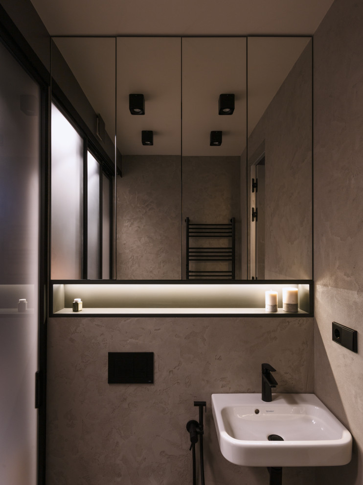 Photo of a medium sized urban cloakroom in Saint Petersburg with a wall mounted toilet, grey walls, porcelain flooring, a console sink, grey floors and a drop ceiling.