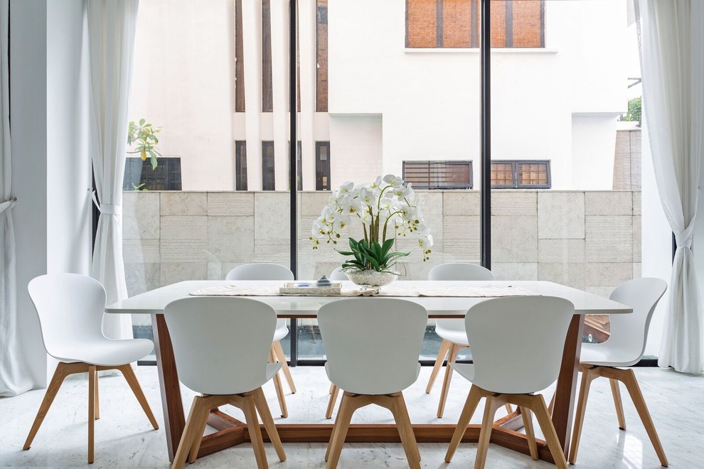 This is an example of a scandinavian separate dining room in Singapore with white walls and grey floor.