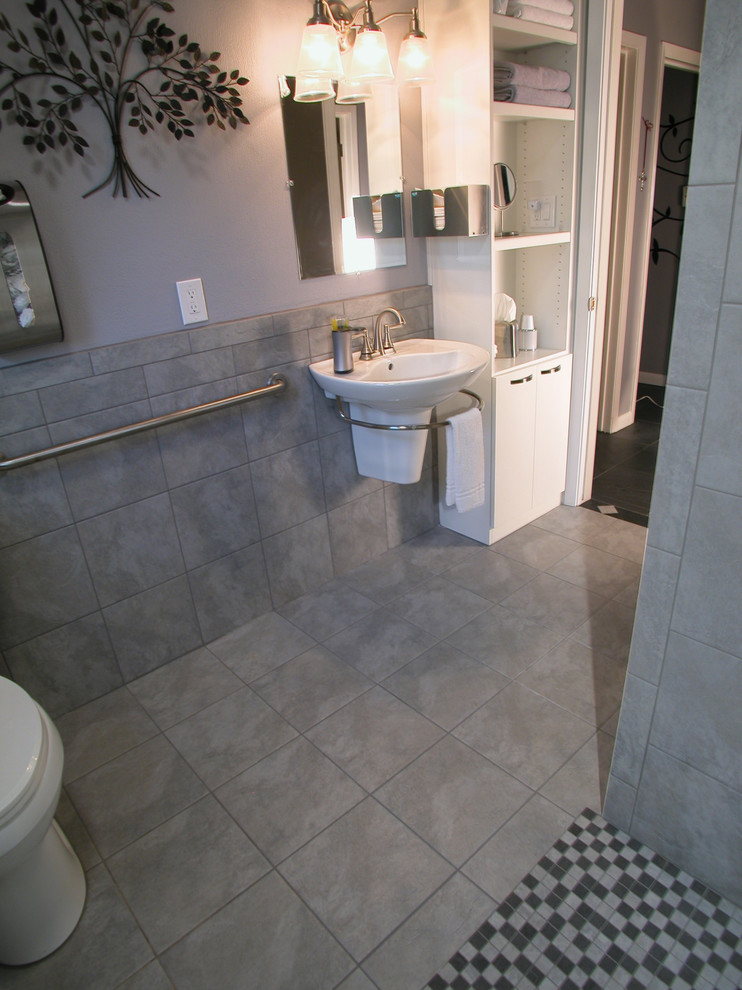 Photo of a small traditional bathroom in Houston with flat-panel cabinets, white cabinets, an open shower, a one-piece toilet, gray tile, porcelain tile, grey walls, porcelain floors and a wall-mount sink.