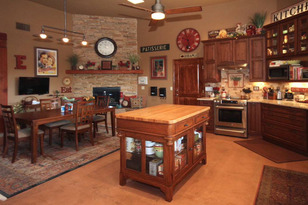 Huge transitional l-shaped concrete floor eat-in kitchen photo in Phoenix with a double-bowl sink, furniture-like cabinets, distressed cabinets, quartzite countertops, multicolored backsplash, stone tile backsplash, stainless steel appliances, brown walls and an island