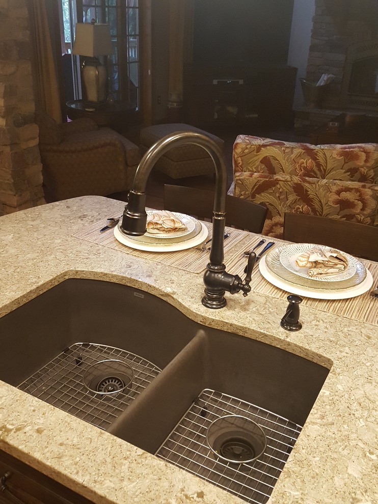 Eat-in kitchen - large transitional l-shaped light wood floor eat-in kitchen idea with an undermount sink, raised-panel cabinets, brown cabinets, quartz countertops, beige backsplash, ceramic backsplash, stainless steel appliances and an island