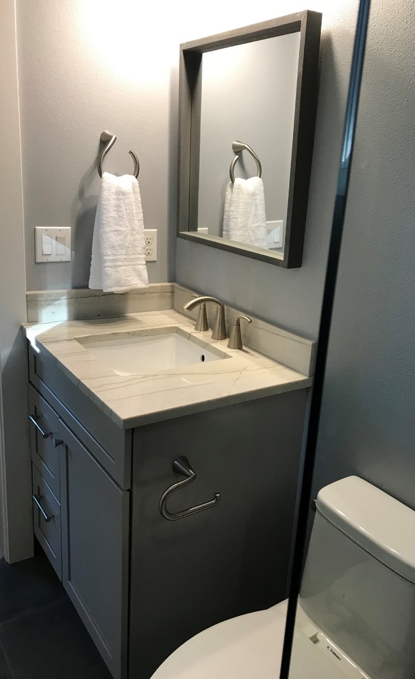 Inspiration for a small transitional laminate floor and gray floor bathroom remodel in Seattle with shaker cabinets, gray cabinets, a two-piece toilet, green walls, a drop-in sink and quartz countertops