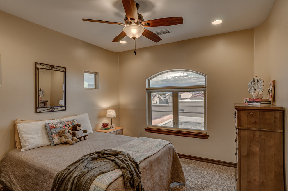 Photo of a mid-sized mediterranean guest bedroom in Albuquerque with beige walls and carpet.