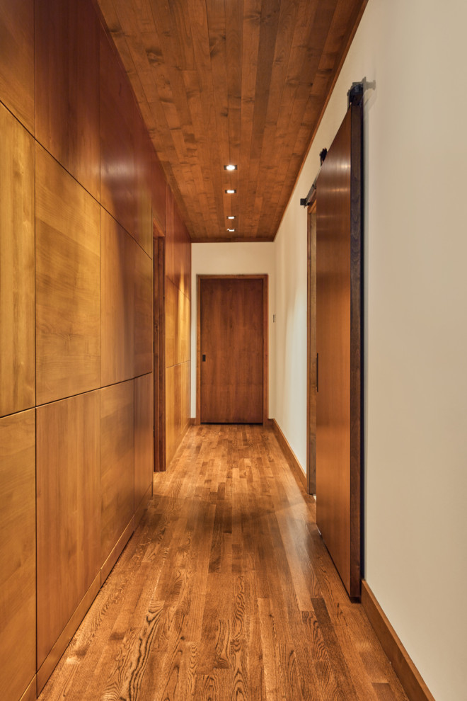 Großer Moderner Flur mit weißer Wandfarbe, braunem Holzboden, braunem Boden, Holzdecke und Holzwänden in Sonstige