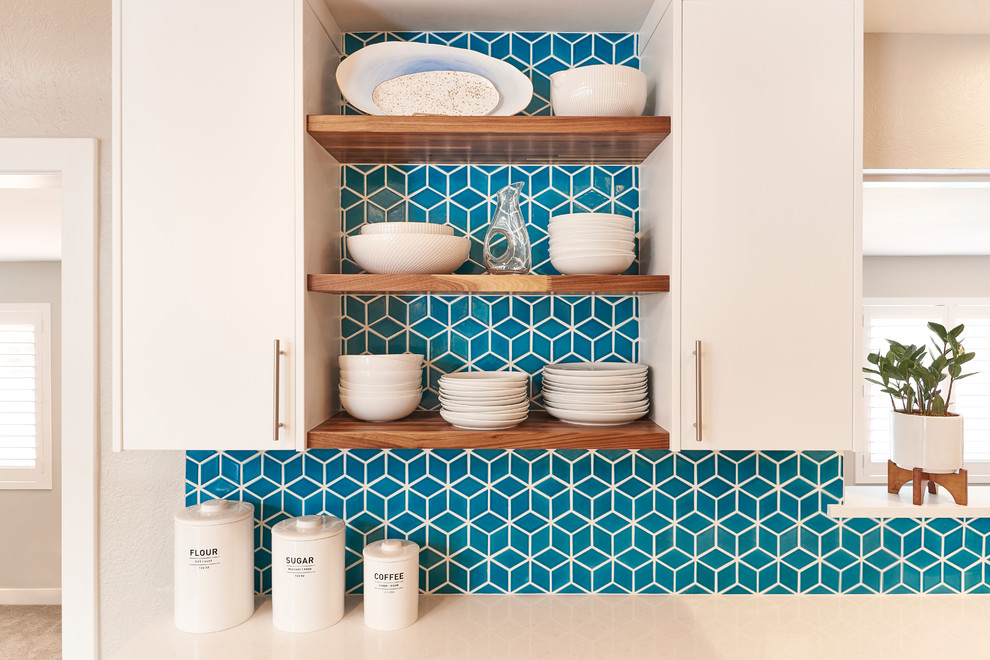 Example of a mid-sized trendy l-shaped medium tone wood floor and brown floor open concept kitchen design in Denver with a single-bowl sink, flat-panel cabinets, white cabinets, quartz countertops, blue backsplash, mosaic tile backsplash, stainless steel appliances and an island