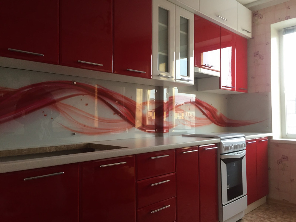 Ejemplo de cocina comedor contemporánea sin isla con puertas de armario rojas, salpicadero rojo y salpicadero de vidrio templado