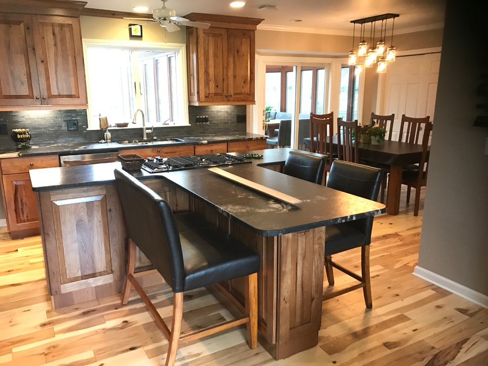 Inspiration for a mid-sized rustic l-shaped eat-in kitchen remodel with an undermount sink, raised-panel cabinets, medium tone wood cabinets, granite countertops and an island