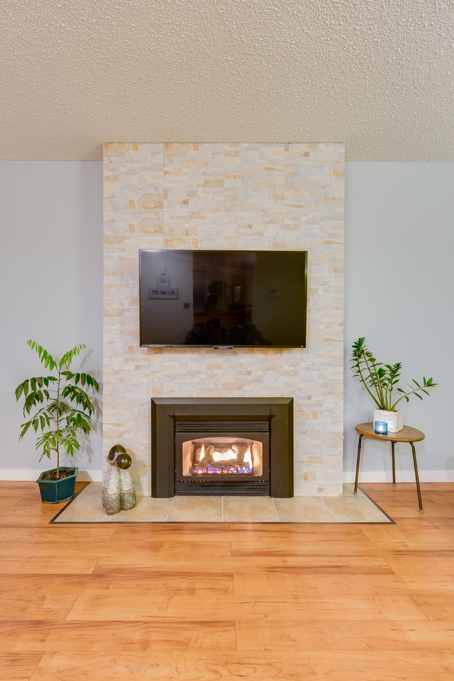 Photo of a mid-sized traditional formal open concept living room in Vancouver with green walls, medium hardwood floors, a standard fireplace, a tile fireplace surround and a wall-mounted tv.