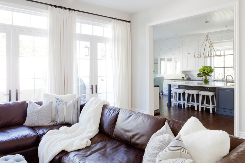 Example of a huge transitional medium tone wood floor family room design in Los Angeles with white walls and a media wall