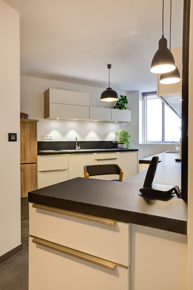 Réalisation d'une cuisine design de taille moyenne avec sol en béton ciré et un sol gris.