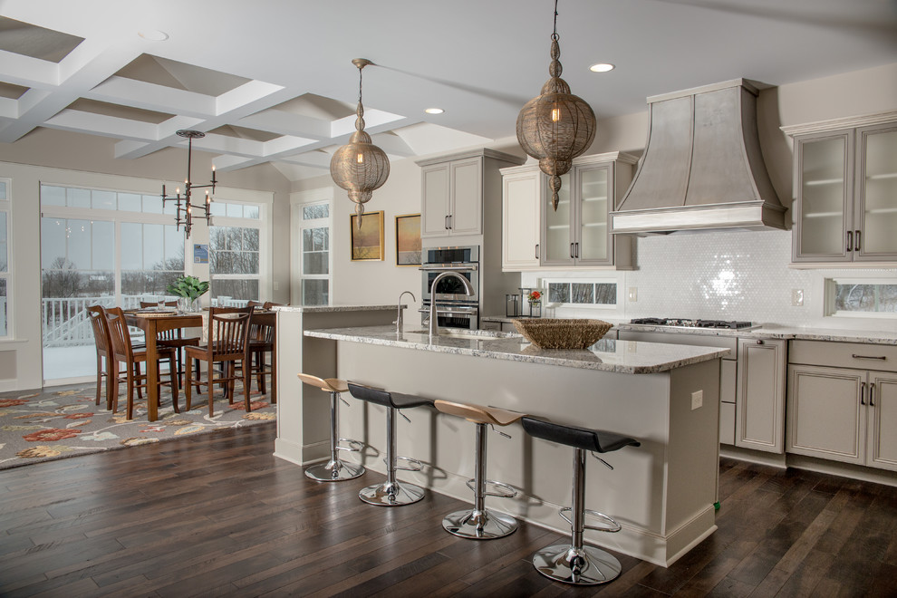 Inspiration for a transitional galley dark wood floor eat-in kitchen remodel in Cleveland with recessed-panel cabinets, gray cabinets, white backsplash, mosaic tile backsplash and an island