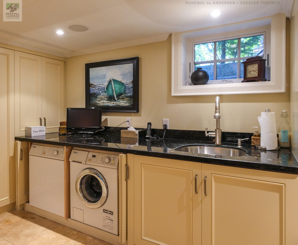 This is an example of a large single-wall separated utility room in Toronto with a submerged sink, beige cabinets, granite worktops, beige walls, ceramic flooring, a side by side washer and dryer, beige floors and black worktops.
