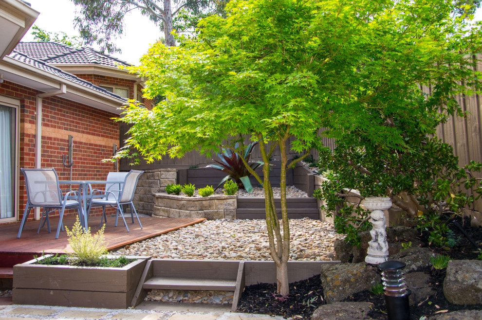 Inspiration for a small contemporary backyard partial sun garden for summer in Melbourne with river rock.