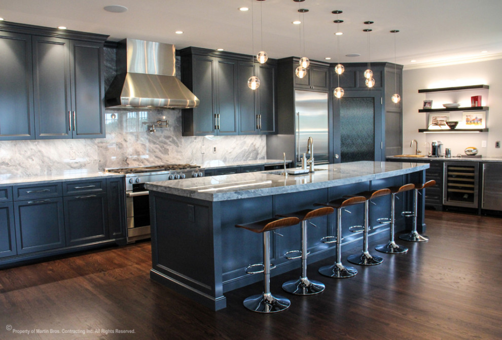 Inspiration for a large transitional single-wall medium tone wood floor open concept kitchen remodel with a double-bowl sink, recessed-panel cabinets, gray cabinets, marble countertops, stainless steel appliances, an island, marble backsplash and multicolored backsplash