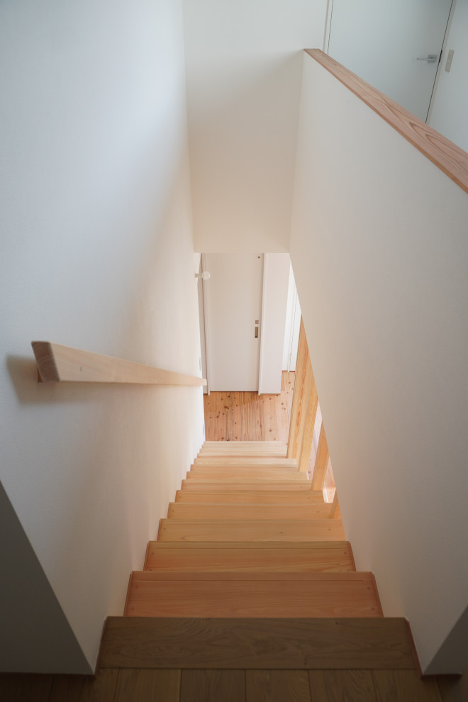 Imagen de escalera suspendida nórdica pequeña con escalones de madera, contrahuellas de madera, barandilla de madera y papel pintado