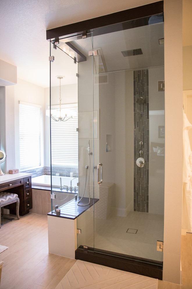 Photo of a large contemporary master bathroom in San Diego with beaded inset cabinets, dark wood cabinets, limestone benchtops, a drop-in tub, an alcove shower, a one-piece toilet, gray tile, grey walls, light hardwood floors and an integrated sink.