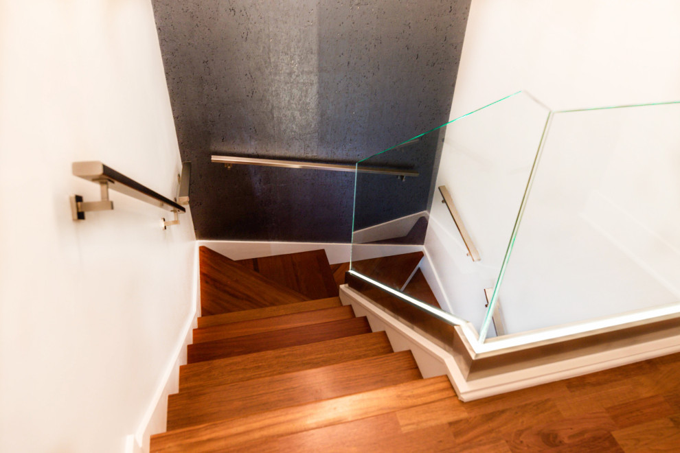 Photo of a contemporary wood curved metal railing staircase in Chicago with painted wood risers and wallpapered walls.