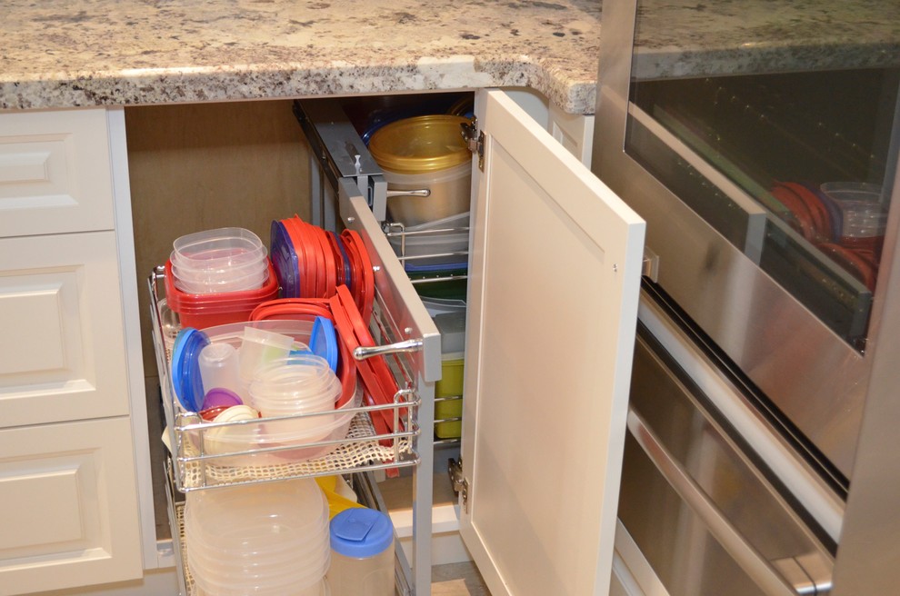 Inspiration for a mid-sized transitional l-shaped porcelain tile enclosed kitchen remodel in Toronto with an undermount sink, raised-panel cabinets, white cabinets, granite countertops, beige backsplash, stainless steel appliances and an island