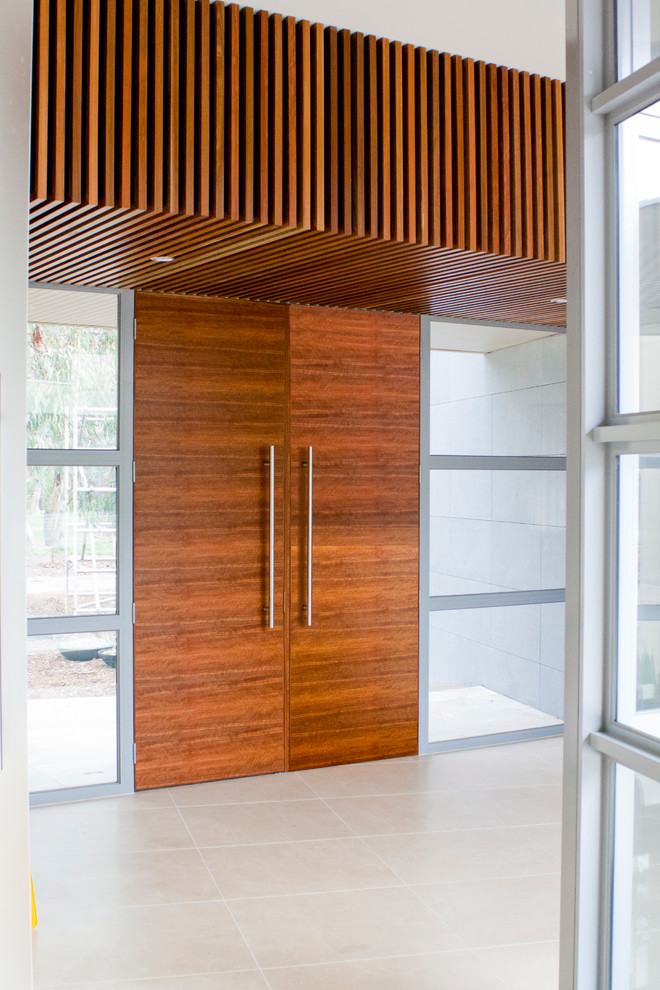 This is an example of a mid-sized contemporary entryway in Melbourne with a double front door and a medium wood front door.