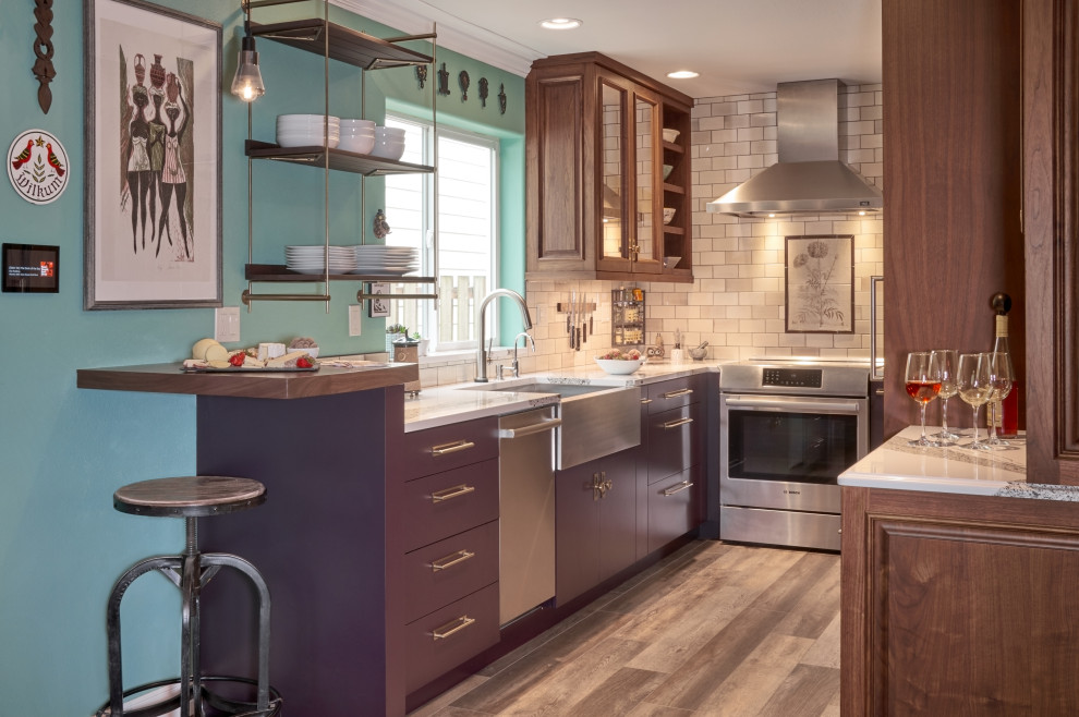 This is an example of a transitional galley eat-in kitchen in Portland with a farmhouse sink, flat-panel cabinets, purple cabinets, quartz benchtops, brown splashback, ceramic splashback, stainless steel appliances, laminate floors, no island, grey floor and white benchtop.