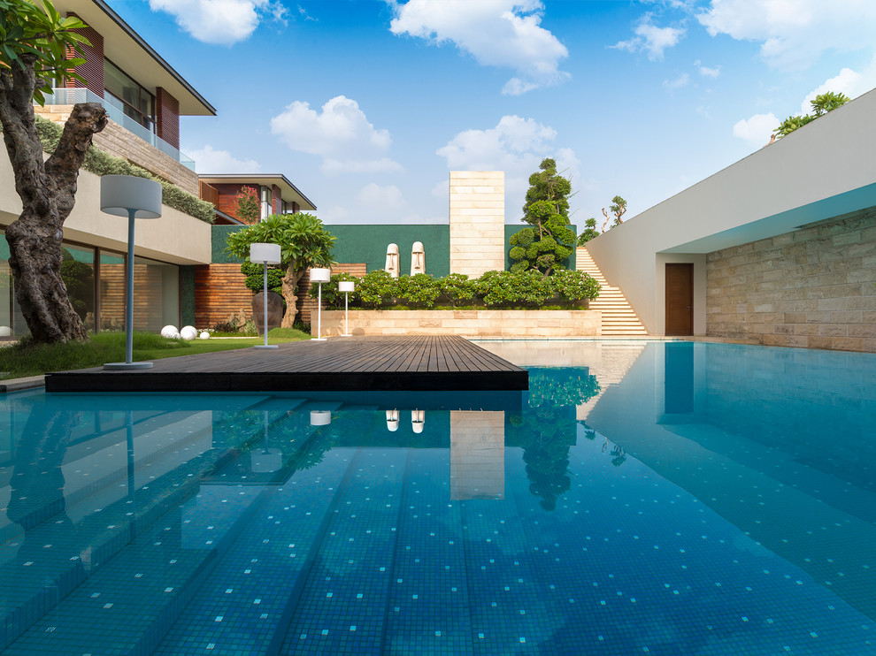 Design ideas for a contemporary Rectangular swimming pool With a Pool House and Decking.