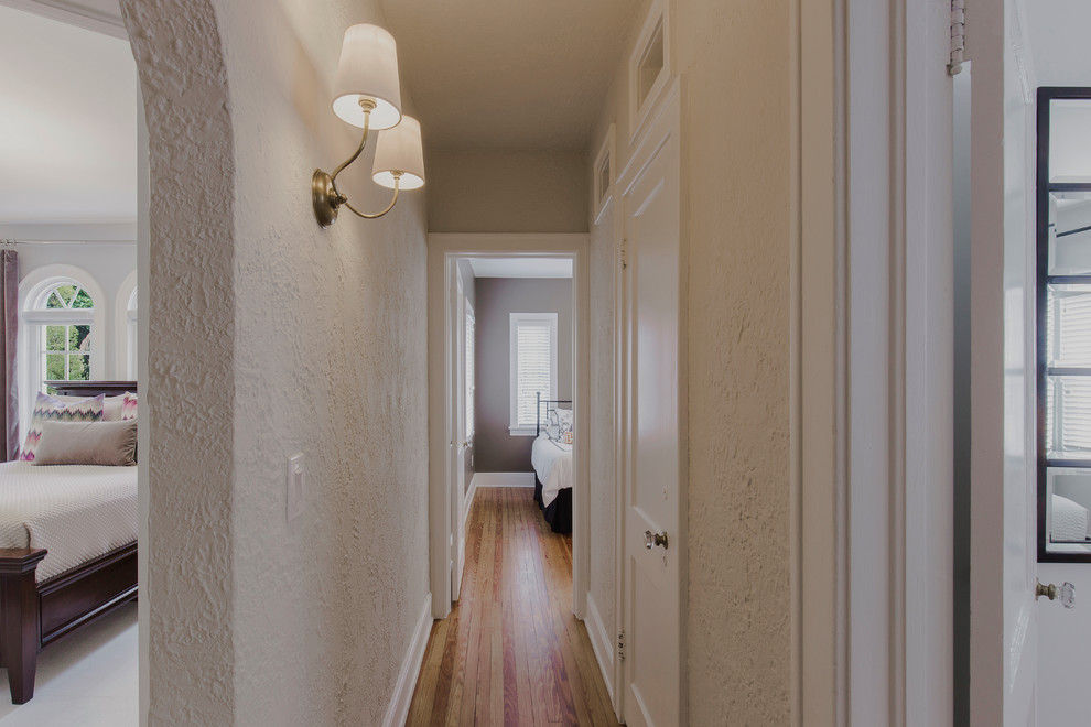 Inspiration for a small hallway in Miami with beige walls and light hardwood floors.