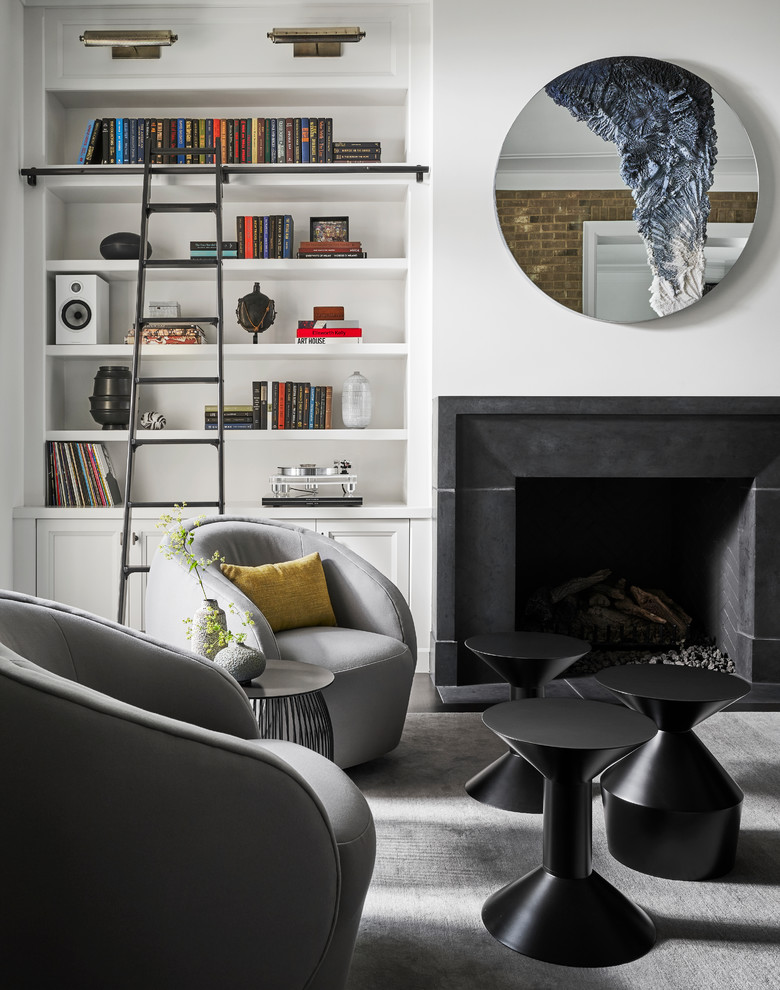 This is an example of a transitional living room in Chicago with a library, white walls, a standard fireplace and no tv.
