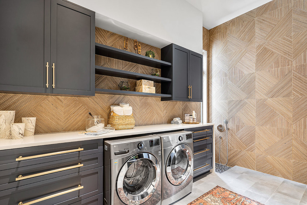 Design ideas for a beach style single-wall utility room in Other with shaker cabinets, grey cabinets, beige walls, a side-by-side washer and dryer, grey floor and white benchtop.