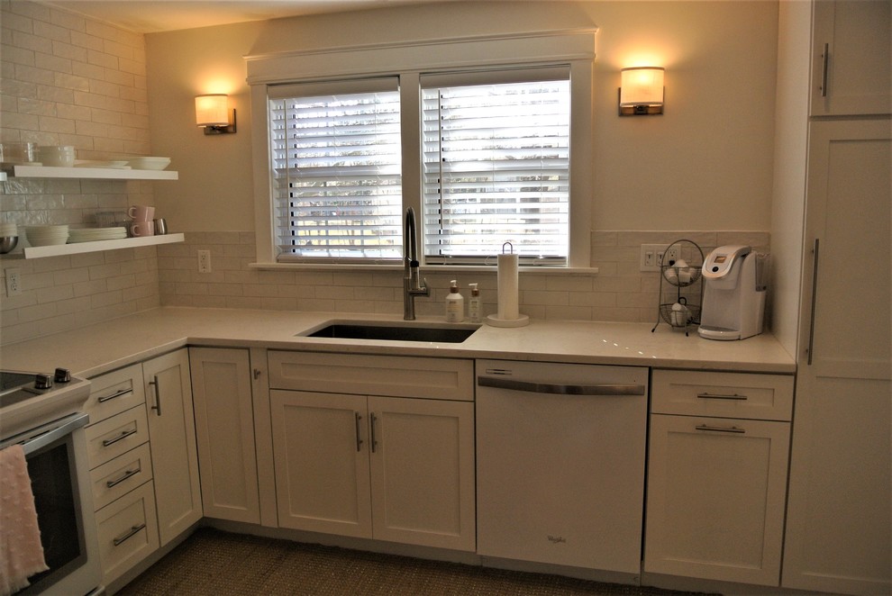 Example of a transitional u-shaped medium tone wood floor eat-in kitchen design in Boston with shaker cabinets, an undermount sink, white cabinets, white backsplash, white appliances and a peninsula