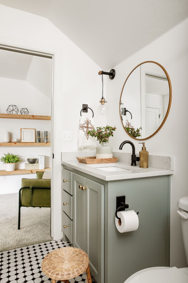 This is an example of a mid-sized transitional 3/4 bathroom in Oklahoma City with shaker cabinets, green cabinets, an alcove tub, an alcove shower, a one-piece toilet, white tile, subway tile, white walls, porcelain floors, an undermount sink, engineered quartz benchtops, black floor, a hinged shower door, white benchtops, a single vanity and a built-in vanity.