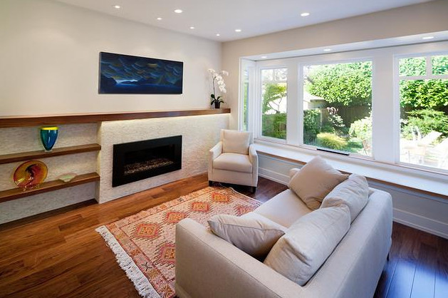 This is an example of a mid-sized traditional living room in Vancouver with beige walls, medium hardwood floors, a ribbon fireplace, a stone fireplace surround, a wall-mounted tv and brown floor.