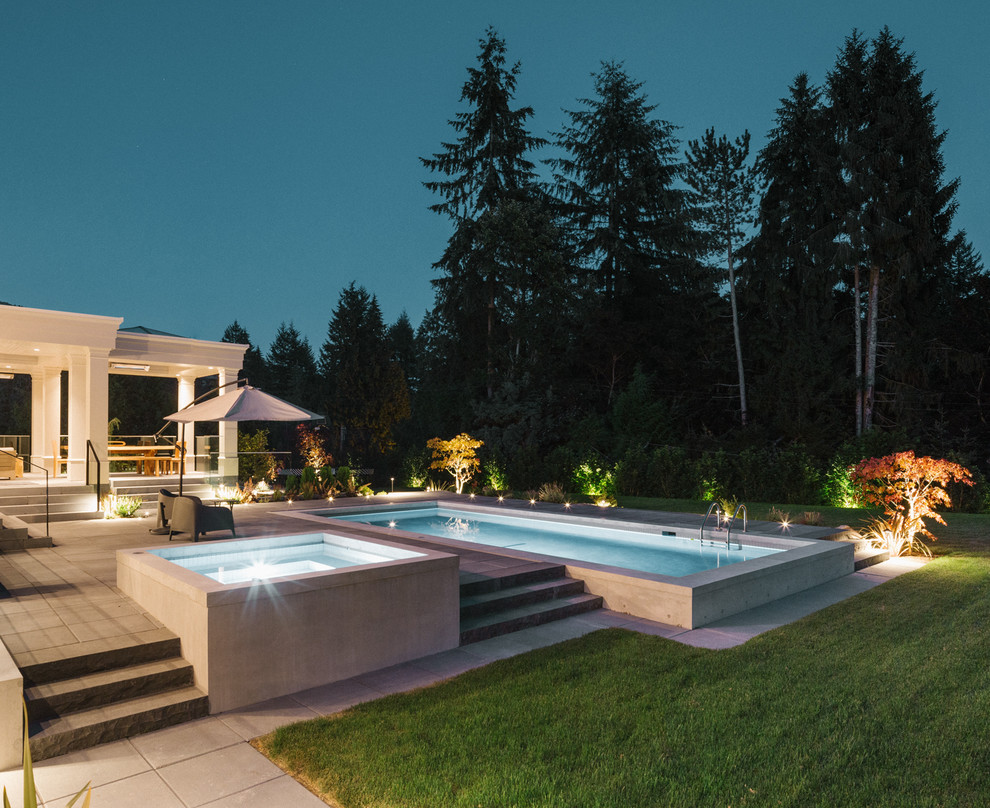 Inspiration for a large transitional backyard rectangular pool in Vancouver with concrete pavers.
